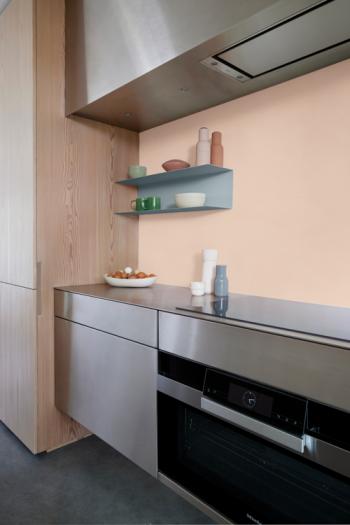 Une cuisine audacieuse avec un mur rose pastel et des armoires en bois