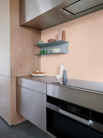 Une cuisine audacieuse avec un mur rose pastel et des armoires en bois