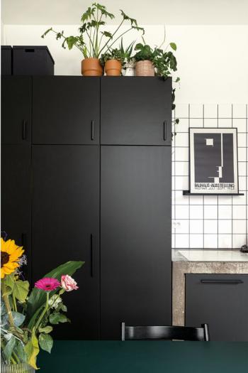 De tegels vormen een ideale combinatie met de zwart geschilderde kastdeuren.