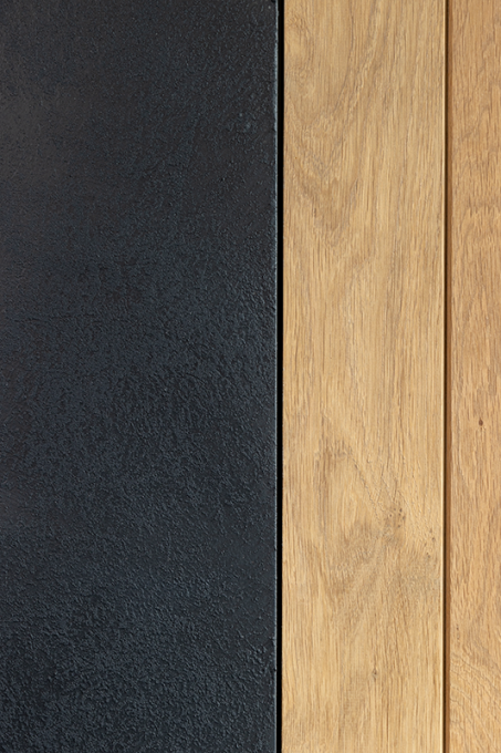 Een zwarte structuurwand geeft een mooi contrast met het hout.